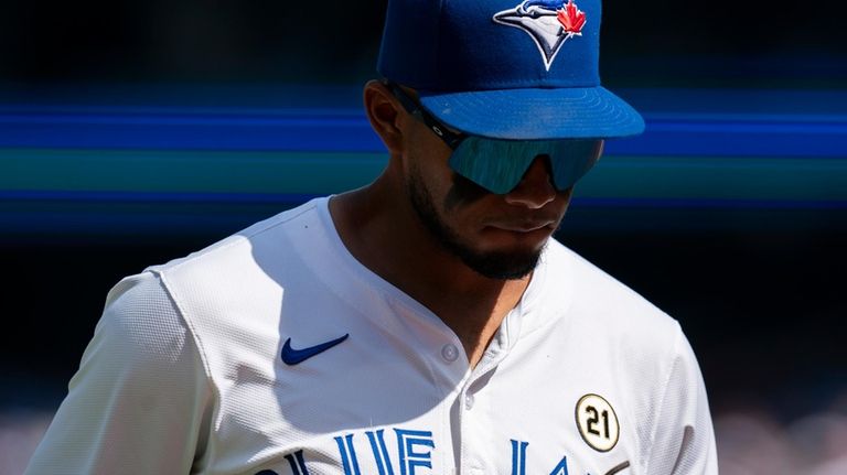 Toronto Blue Jays Leo Jiménez walks to the dugout between...