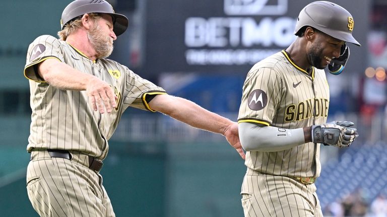 San Diego Padres third base coach Tim Leiper, left, congratulates...