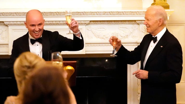 Utah Gov. Spencer Cox, left, and President Joe Biden toast...
