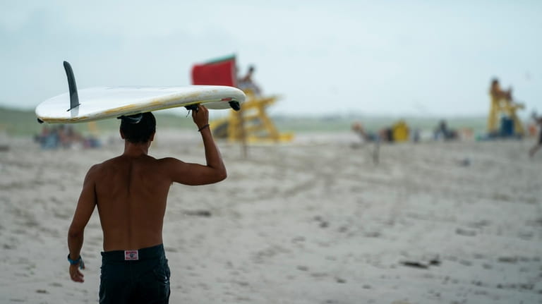 A surfer hits the water at Lido Beach Town Park.