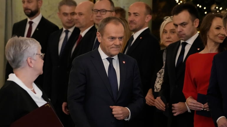 The new Poland's Prime Minister Donald Tusk, centre, walks past...