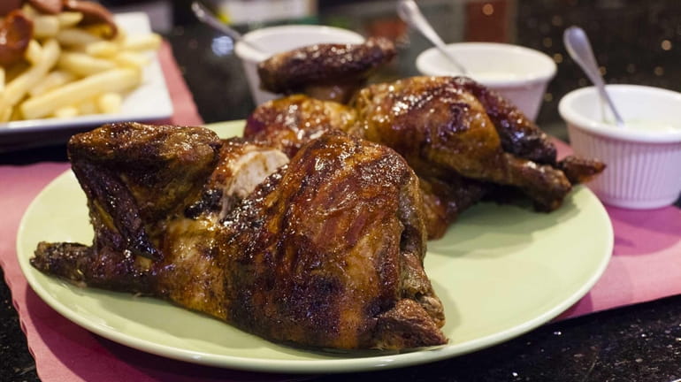 Family-style pollo a la brasa, or rotisserrie chicken, is featured...