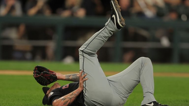 Cleveland Guardians' pitcher Ben Lively lays on the field after...