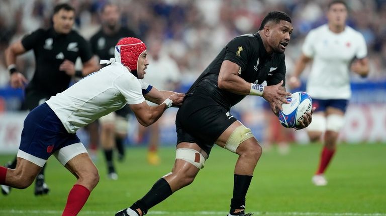 France's Gabin Villiere, left, tries to hold back New Zealand's...