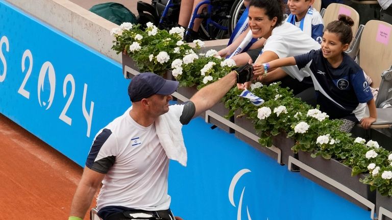 Israel's Adam Berdichevsky shakes hands with his wife Hila and...