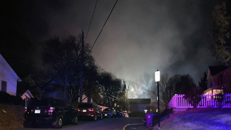 Smoke rises over a neighborhood where Virginia police say a...