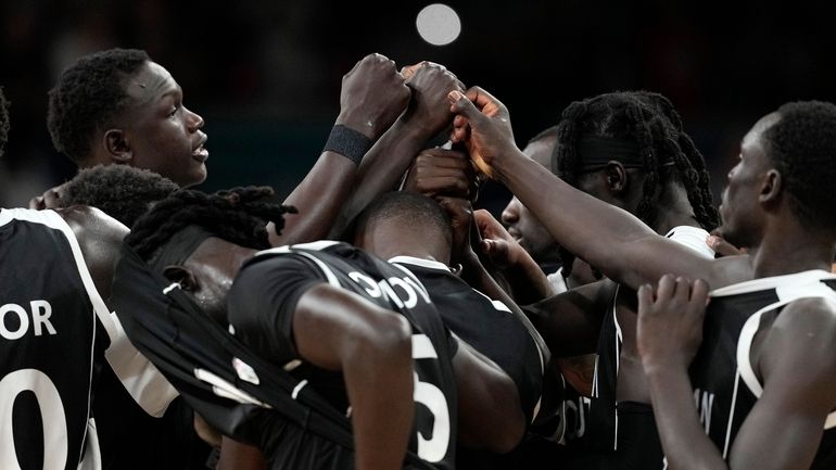 Members of the South Sudan team gather after being defeated...