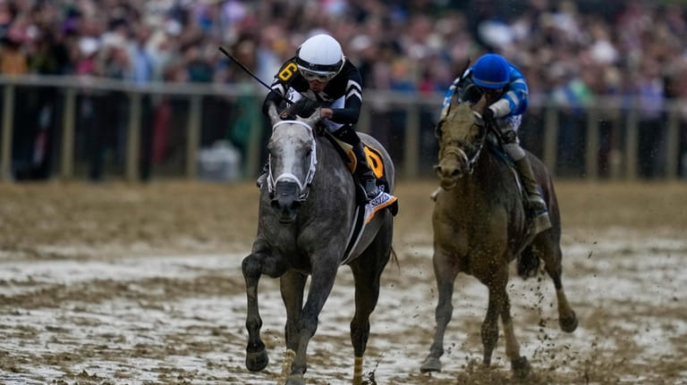 Jaime Torres, left, atop Seize The Grey, crosses the finish...