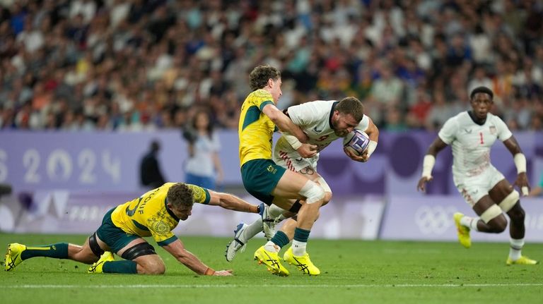 United States' Steve Tomasin, is tackled by Australia's Ben Dowling...