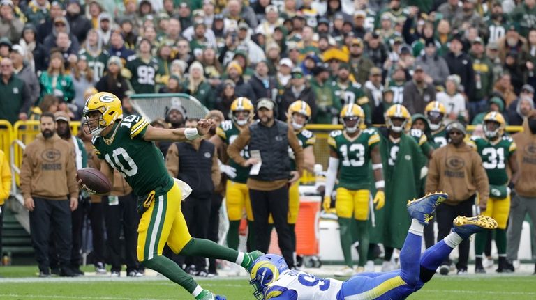 Green Bay Packers quarterback Jordan Love (10) is tackled by...