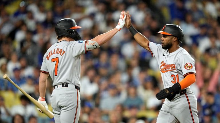 Baltimore Orioles' Cedric Mullins, right, is congratulated by Jackson Holliday...