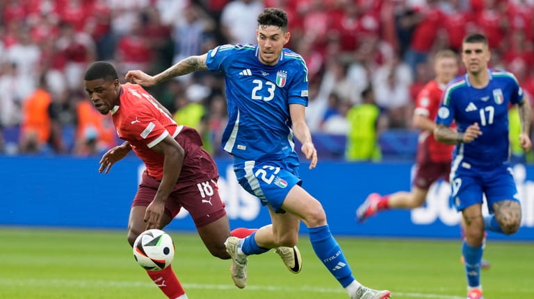 Italy's Alessandro Bastoni vies for the ball with Switzerland's Kwadwo...