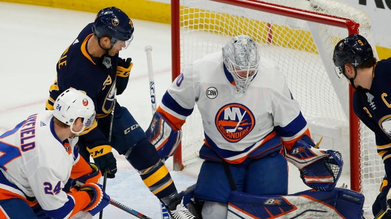 Sabres forward Jason Pominville is stopped by Islanders goalie Robin...
