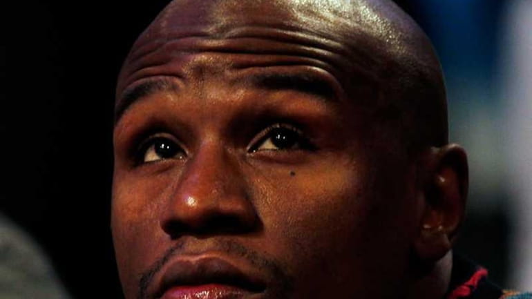 Boxer Floyd Mayweather Jr. sits courtside during the Taco Bell...