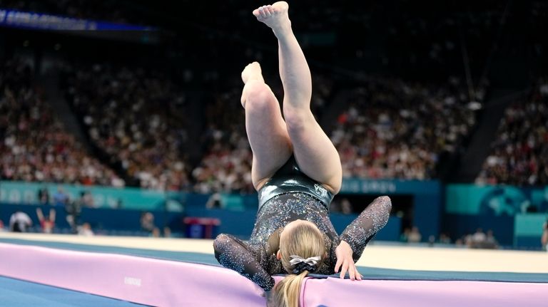 Jade Carey, of United States, falls as she competes on...