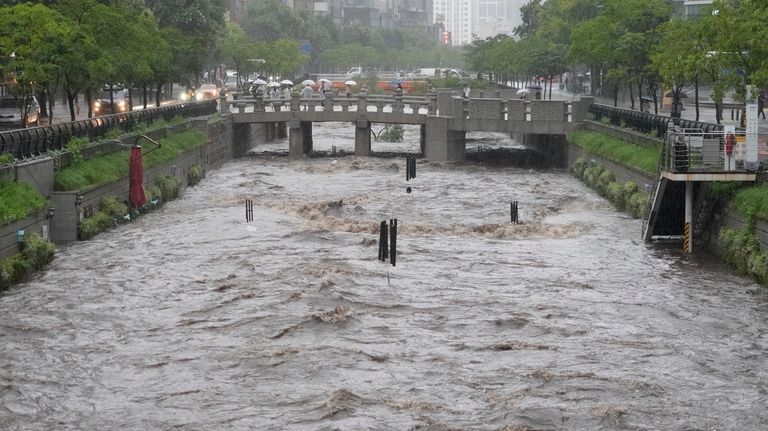 Cheonggye Stream is flooded after a heavy rain pounded in...