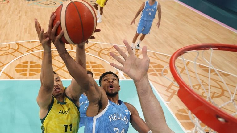 Giannis Antetokounmpo, of Greece, shoots in front of Dante Exum,...