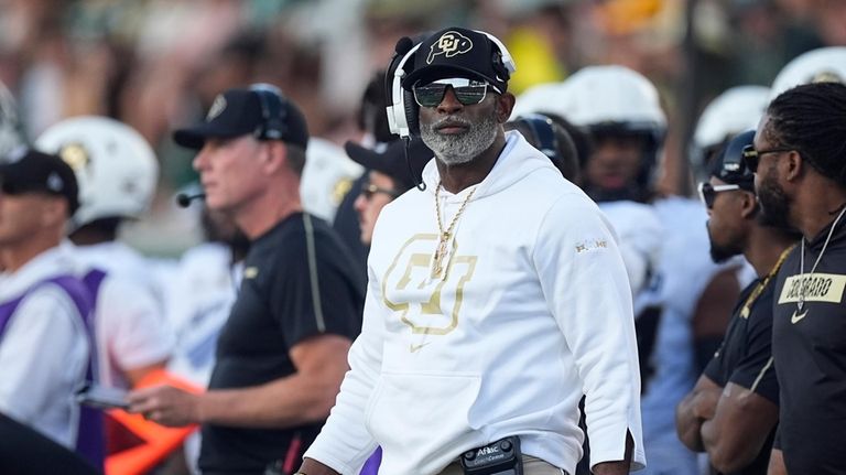 Colorado head coach Deion Sanders checks the video board in...