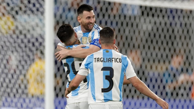 Argentina's Lionel Messi is congratulated after scoring his side's 2nd...