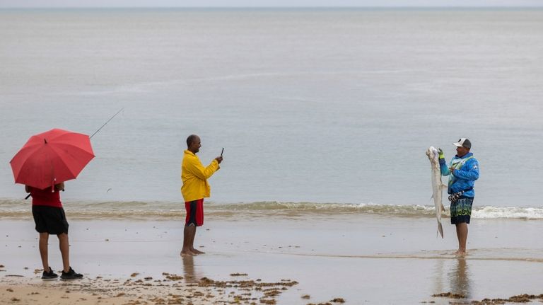 A man pose with a fish after Tropical Storm Ernesto...