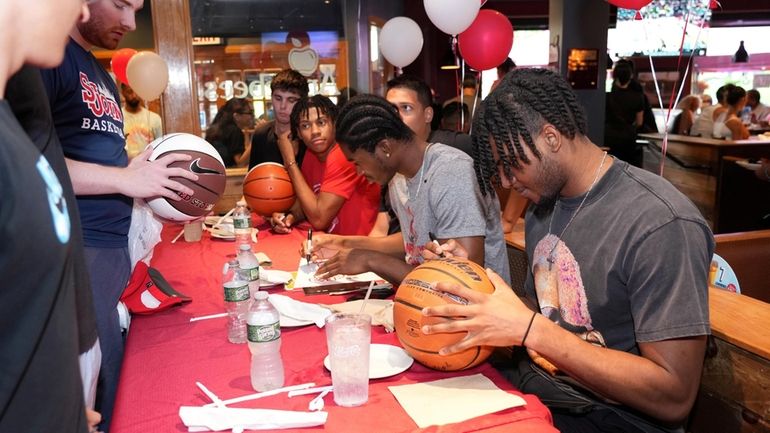 St. John's men's basketball players signing autographs at Applebee's in...