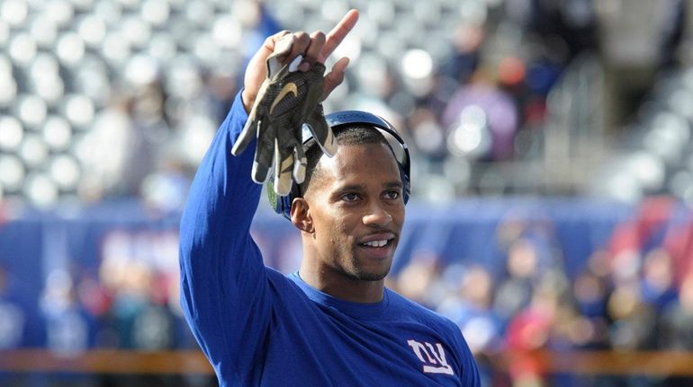 New York Giants wide receiver Victor Cruz waves to fans...