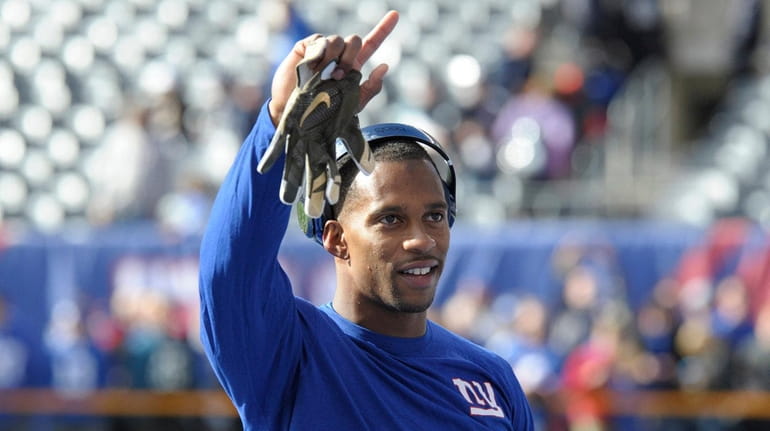 New York Giants wide receiver Victor Cruz waves to fans...
