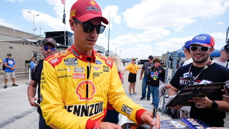 Joey Logano sings autographs before a practice session for the...