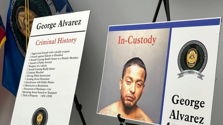 Poster boards regarding George Alvarez stand during a news conference...