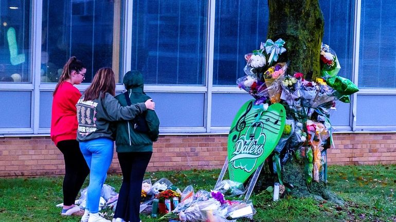 Students visit a makeshift memorial, which honors victims of the bus...