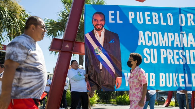 Supporters of El Salvador President Nayib Bukele campaign for his...