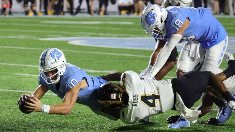 North Carolina quarterback Drake Maye (10) dives for additional yards...