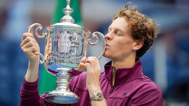 Jannik Sinner, of Italy, kisses the championship trophy after defeating...