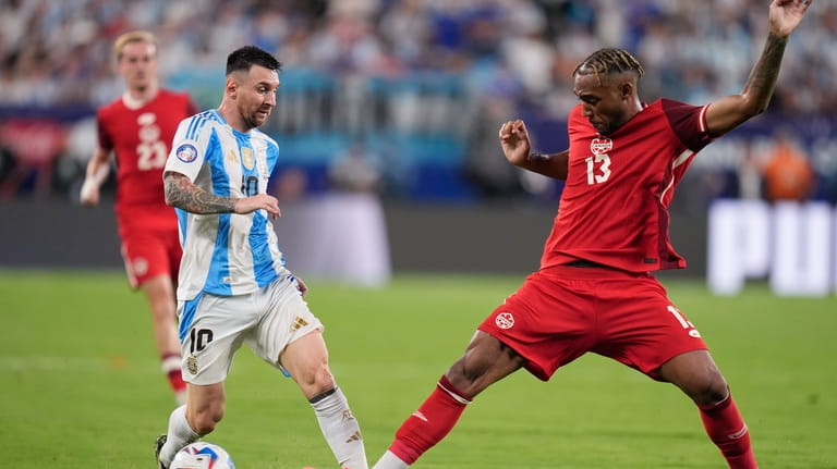 Argentina's Lionel Messi, left, vie for the ball with Canada's...