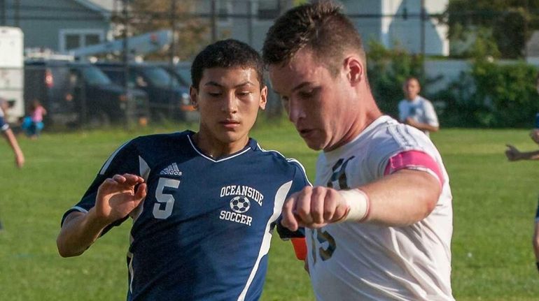 Hicksville's Matthew Sloan, right, and Oceanside's Nicholas Triano go after...