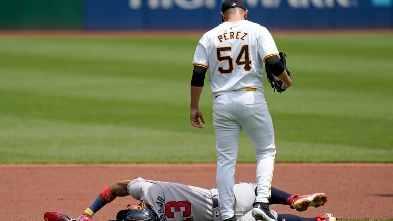 Pittsburgh Pirates starting pitcher Martín Pérez (54) checks on Atlanta...