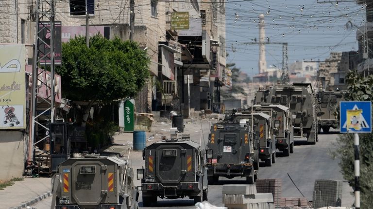 A column of Israeli Army armored vehicles leave following a...