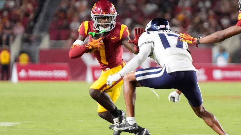 Southern California wide receiver Zachariah Branch, left, fends off Utah...