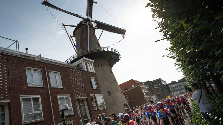 The pack passes a windmill during the start of the...