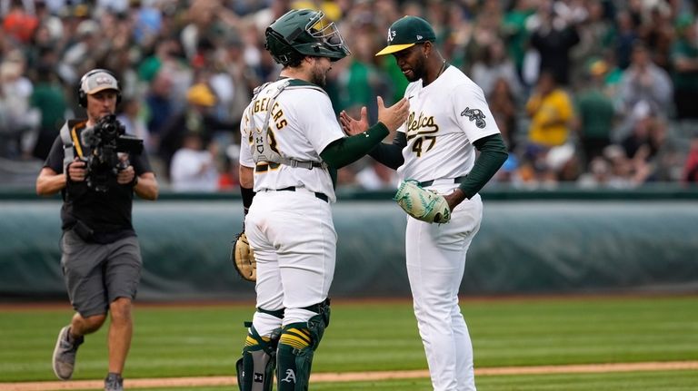 Oakland Athletics catcher Shea Langeliers, front left, and pitcher Michel...