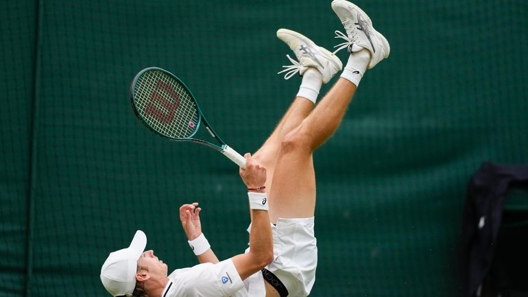 Alex de Minaur of Australia falls during his fourth round...