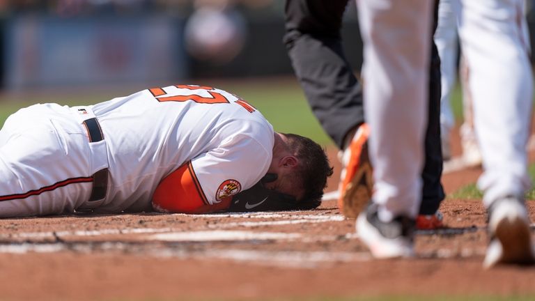 Baltimore Orioles' James McCann reacts after being hit by a...