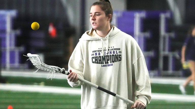 Northwestern's Izzy Scane plays with a ball while warming up...