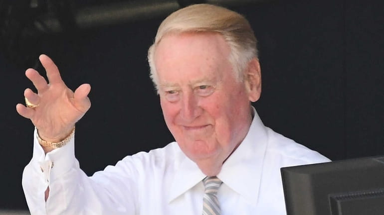 Los Angeles Dodgers broadcaster Vin Scully acknowledges the umpire crew...