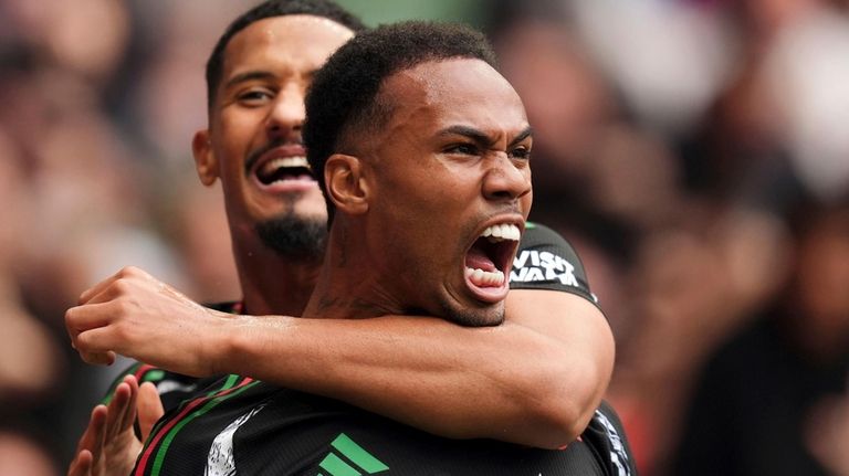 Arsenal's Gabriel, foreground, celebrates with teammate William Saliba after scoring...