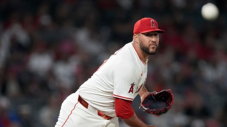 Los Angeles Angels relief pitcher Carlos Estevez tries to pick...