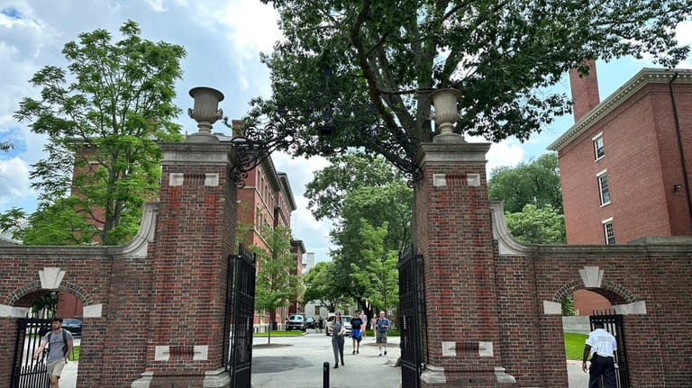 Students walk through a gate at Harvard University, Thursday, June...