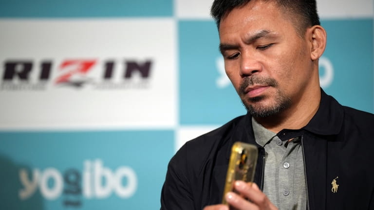 Former Filipino boxer Manny Pacquiao takes photos with his mobile...