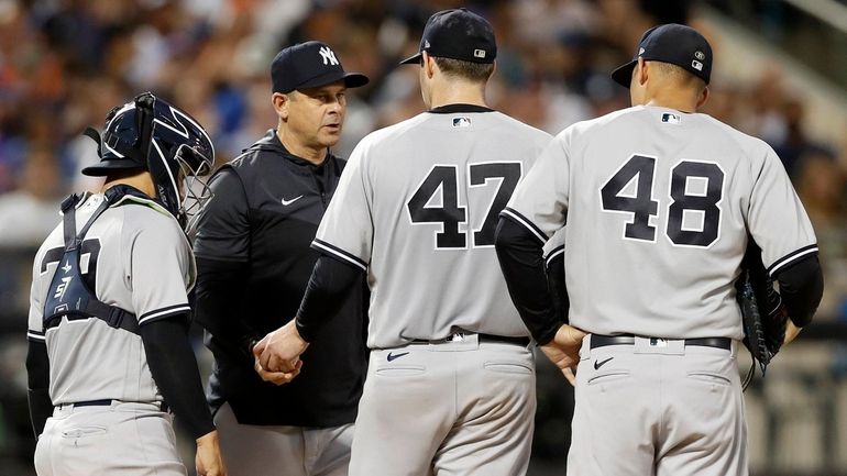 Jordan Montgomer of the Yankees hands the ball to manager Aaron...