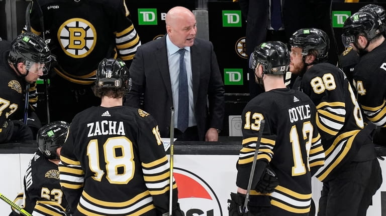 Boston Bruins head coach Jim Montgomery, center top, talks to...